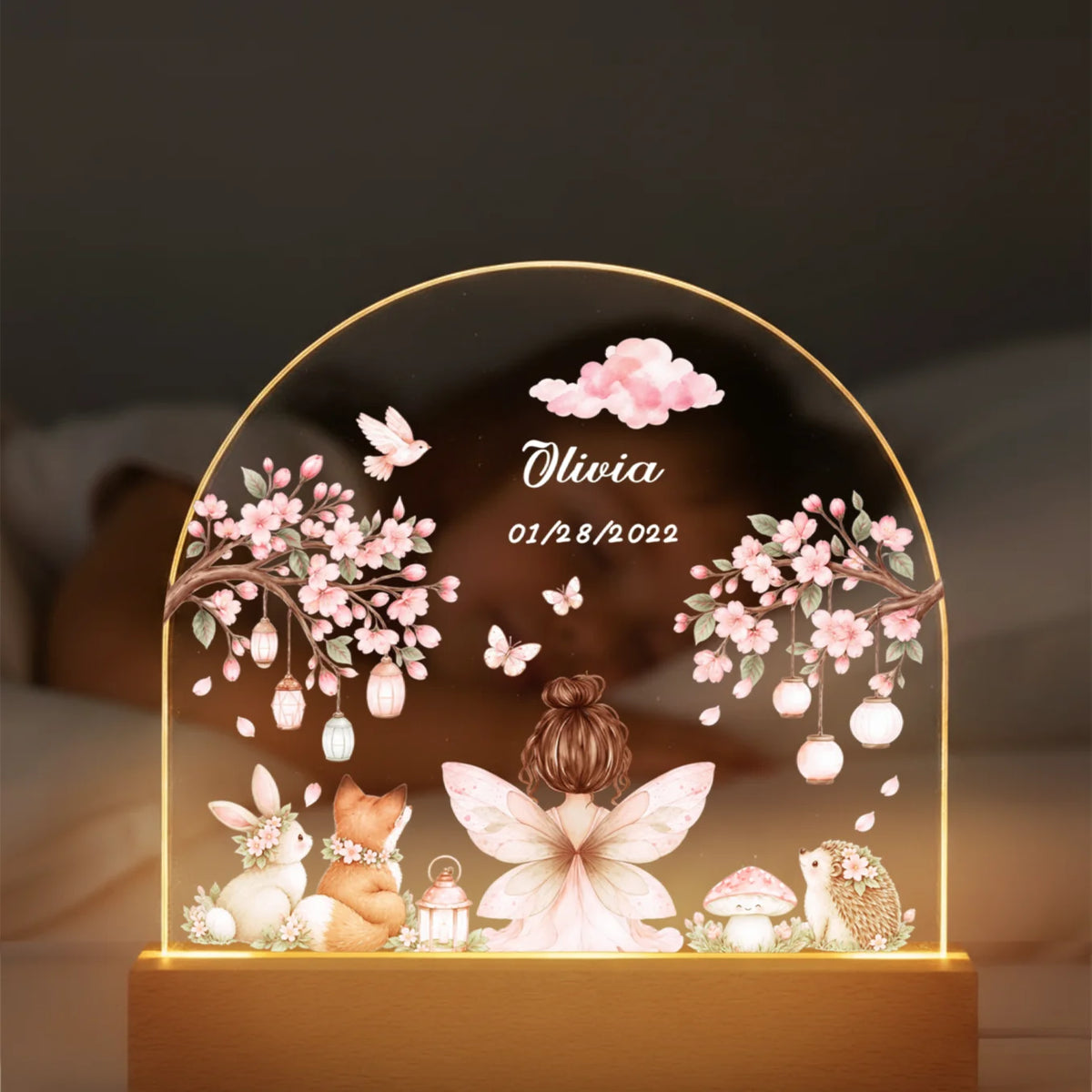 Fairy night light with name and date glowing in front of a sleeping child