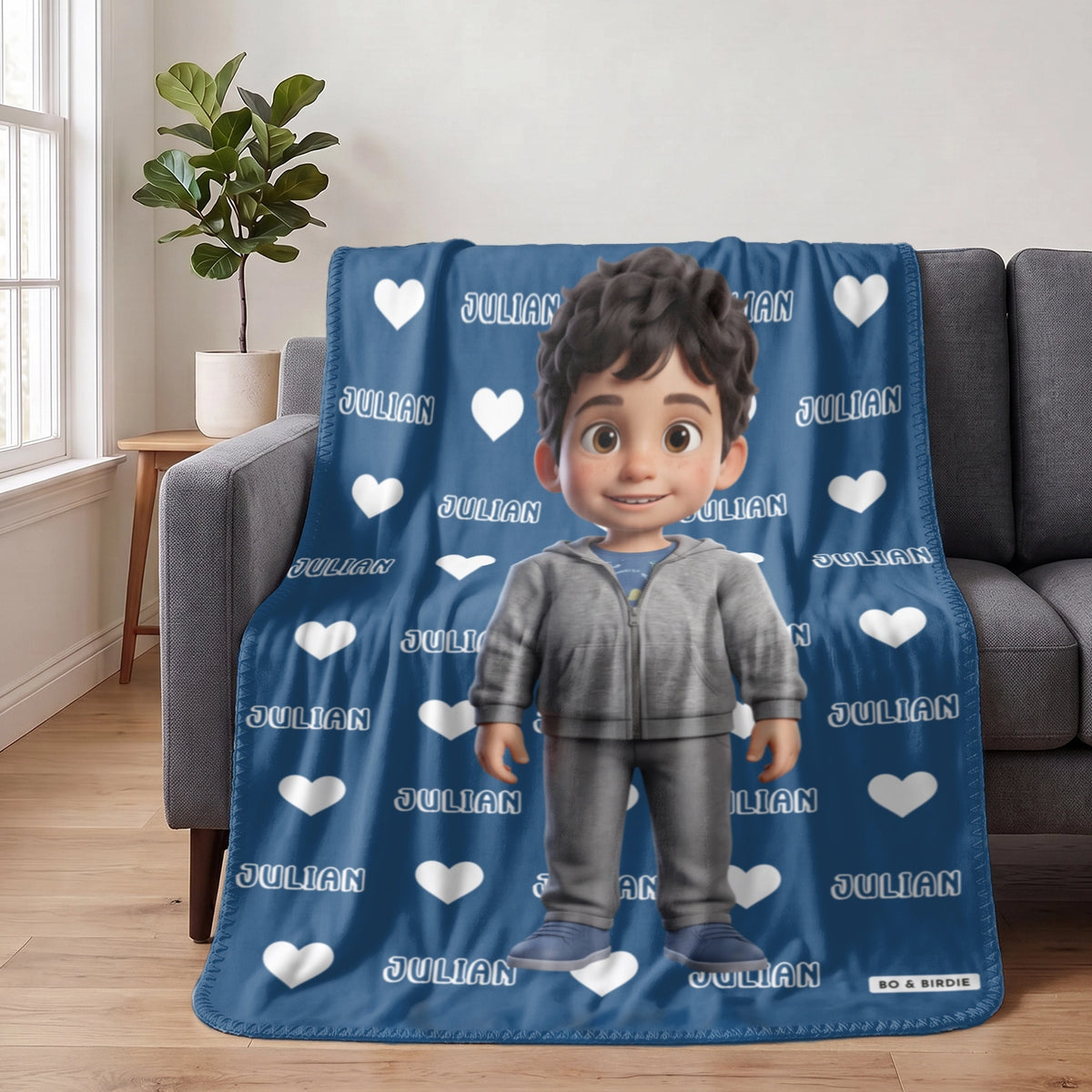 Blue Cartoon Character blanket with the name Julian draped over a sofa