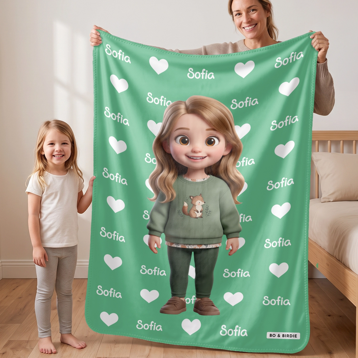 Mom and daughter holding up the green Cartoon Character blanket with the name Sofia