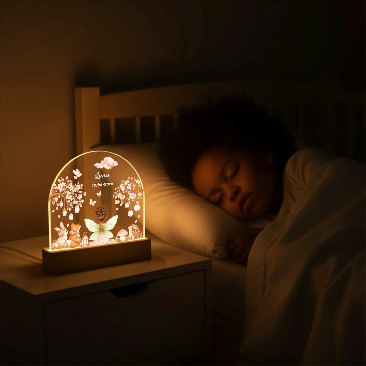 Girl sleeps beside the glowing Fairy night light on the nightstand